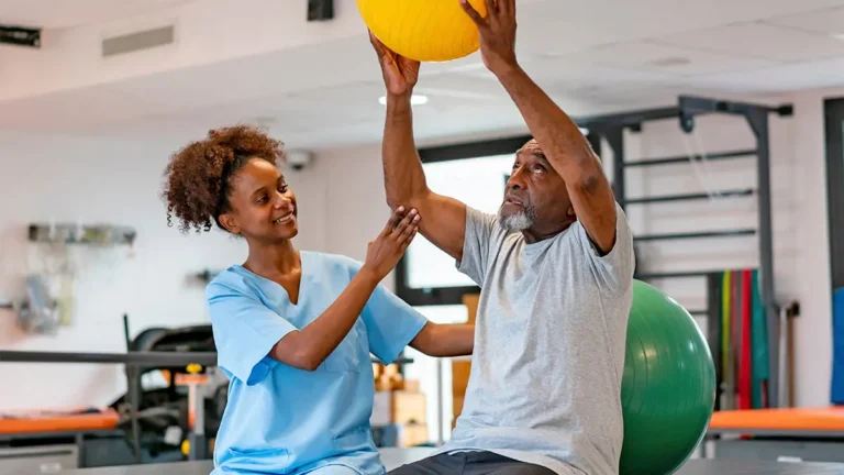 Profissional terapeuta ocupacional auxiliando paciente na reabilitação física e emocional